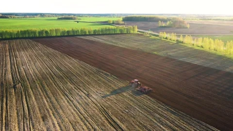 Farmer plowing fields at sunset with modern tractor Stock Footage 314667538