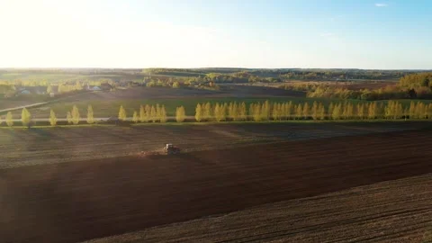Farmer plowing fields at sunset with tractor Stock Footage 309829236