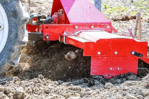Farmer plows the field. Small tractor with a plow in the field. Cultivation. Stock Photos