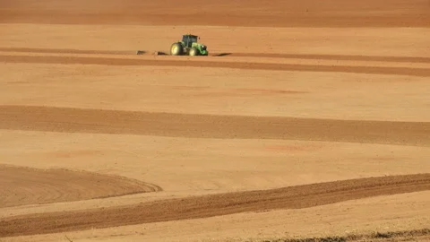 Farmer plows with his tractor on his farm for peanuts planting Stock Footage 139724941