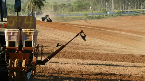 Farmer plows with his tractor on his farm for peanuts planting Video stock 144232184