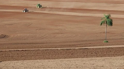 Farmer plows with his tractor on his farm for peanuts planting in the rural area Stock Footage 148797845