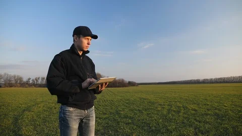 Farmer with portable tablet computer in a wheat field Stock Footage 106206997