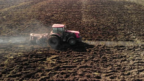 Farmer on a powerful tractor handles heavy swampy black soil with a disk Vídeos de archivo 130326482