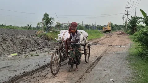 Farmer Pulling Loaded Cargo Tricycle On Muddy Road In Bangladesh Stock Footage 338445677