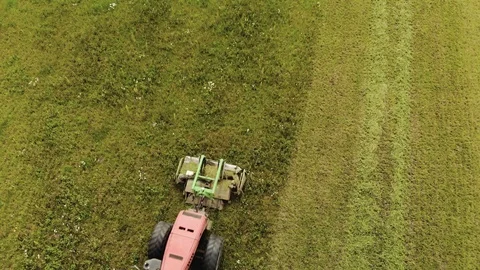 Farmer on a red tractor with a combined mounted mower with disc rotary knives 스톡 동영상 119643715