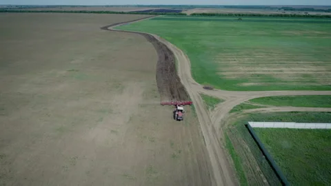 A farmer on a red tractor plows the land in his small plot. Work for farming Vídeos de archivo 157674250