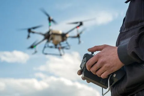 A farmer with a remote control in his hands for spraying with an agrodrone .. Stock Photos