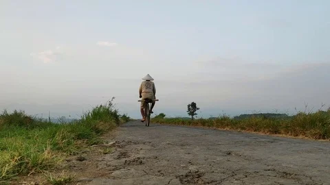 A farmer rides a bicycle 스톡 동영상 112285667