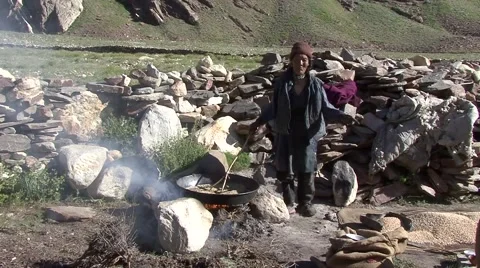Farmer roasting barley over fire. Stock Footage 58352893