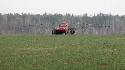Farmer on a self-propelled sprayer processes rising winter crops in farmland Stock Footage 127556769