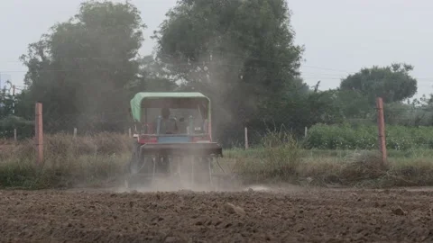 Farmer sowing seeds and digging soil in the field with the help of tractor Stock Footage 172487500