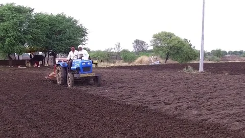 Farmer sowing seeds with automatic seed cum fertilizer drill machine Stock Footage 77572729