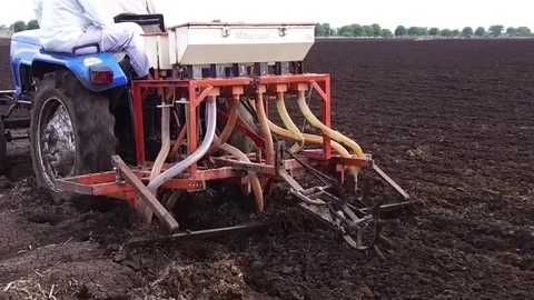 Farmer sowing seeds with automatic seed cum fertilizer drill machine Stock Footage 77572970