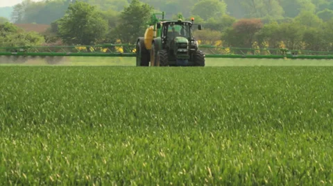 Farmer spraying pesticides on a field of wheat Stock Footage