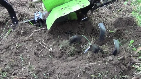 Farmer in spring and autumn operates a cultivator to plow the land during the Stock Footage 277837059