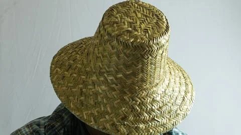 Farmer in straw hat facing downward with face hidden, close-up portrait on .. Stock Photos