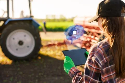 A farmer with a tablet successfully uses artificial intelligence at an agri.. Foto stock