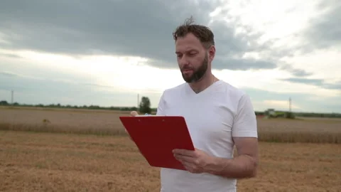 A farmer with a tablet for taking notes stands Stock Footage 250951157
