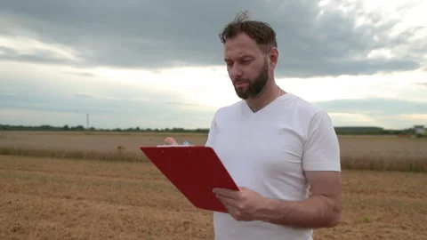 A farmer with a tablet for taking notes stands Stock Footage 250951176