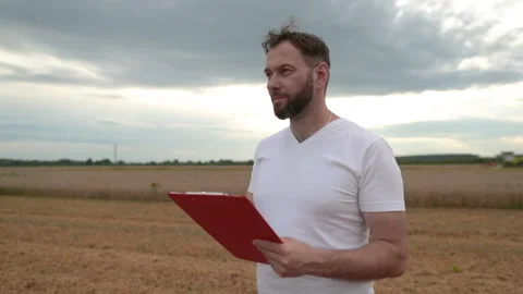 A farmer with a tablet for taking notes stands Stock Footage 250951259