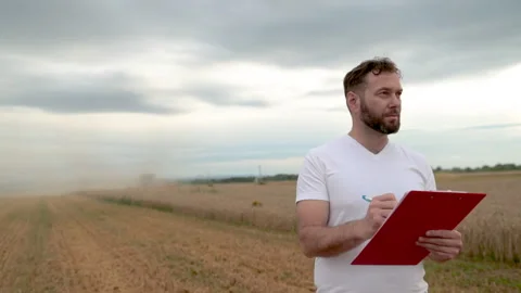A farmer with a tablet for taking notes stands Stock Footage 250951437