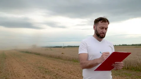 A farmer with a tablet for taking notes stands Stock Footage 250951525