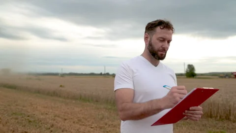 A farmer with a tablet for taking notes stands Stock Footage 250951716