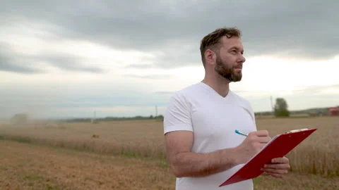 A farmer with a tablet for taking notes stands Stock Footage 250952130