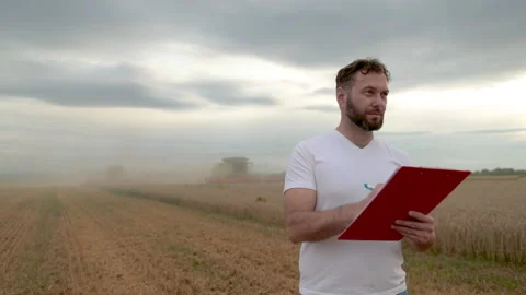 A farmer with a tablet for taking notes stands Stock Footage 250952380