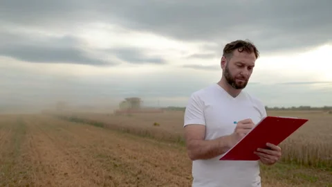 A farmer with a tablet for taking notes stands Stock Footage 250952389