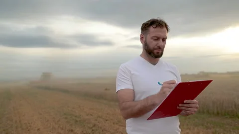 A farmer with a tablet for taking notes stands Stock Footage 250953215