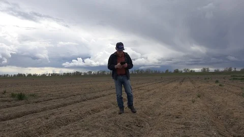 Farmer testing soil, storm cloud brewing Stock Footage 87395476