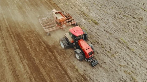 Farmer on a tractor with a container for sowing grain crops working in the 動画素材 127159483
