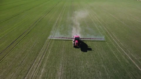 Farmer on tractor in field. Top view of tractor driving across field spraying Stock Footage 279470633