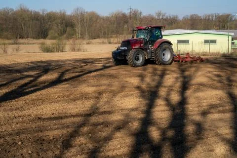 Farmer in tractor preparing land with seedbed cultivator, morning sun, czech Stock Photos