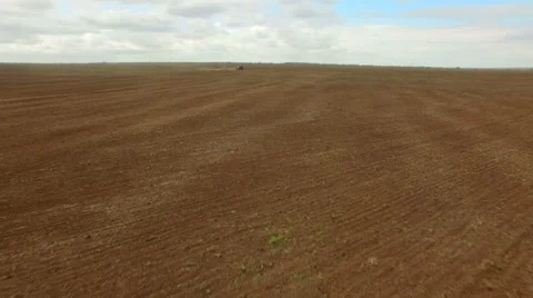Farmer in tractor preparing land for sowing, agricultural work plowing land on a Stock Footage 62763976
