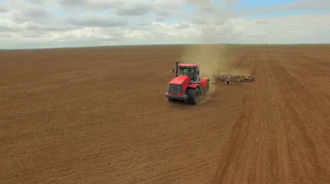 Farmer in tractor preparing land for sowing, agricultural work plowing land on a Stock Footage 62764916