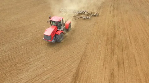 Farmer in tractor preparing land for sowing, agricultural work plowing land on a Stock Footage 62765116