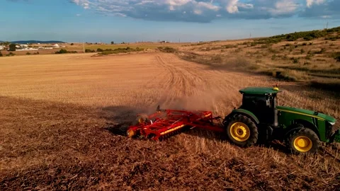 A farmer on a tractor with a seeder sows grain in plowed land in a private field Vídeos de archivo 229417908
