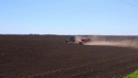 Farmer with tractor seeding crops at field Stock Footage 258619121