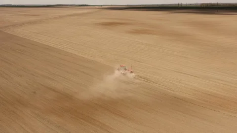Farmer with tractor seeding - sowing crops at agricultural fields in spring Stock Footage 129351275