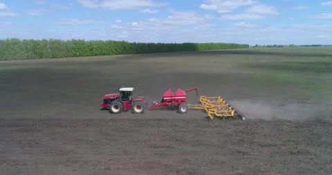 A farmer on a tractor sows and plows the soil at the same time. Stock Footage 160547270