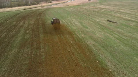 Farmer in a tractor throws manure on the field Stock Footage 155126866