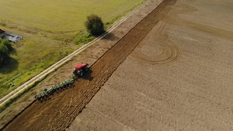 A farmer on a tractor uses a harrow seeder, cultivates the soil, prepares the Vidéo 123465655
