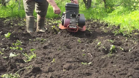 Farmer trying to start a stalled, broken cultivator. Stock Footage 133005069
