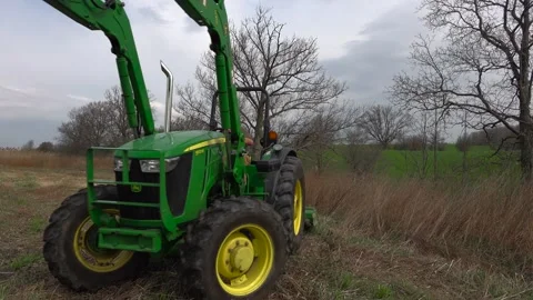 Farmer Turning Green Tractor While Cutting Grass with Brush Hog on a Farm Stock Footage 346961639