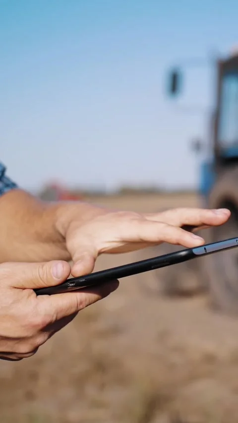 Farmer is using digital tablet. close-up. on farm field, near tractor, on farm Stock Footage 308356961
