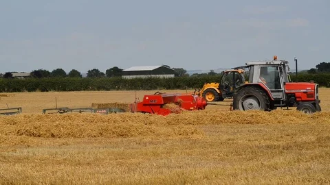 Farmer using straw baling machine at harvest united kingdom Stock Footage 77483461