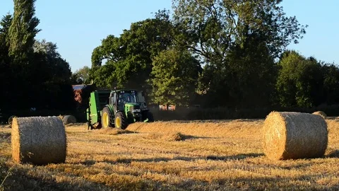 Farmer using straw baling machine at harvest time ellerton yorkshire uk Stock Footage 78906538